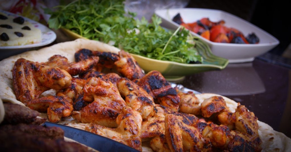 A grilled chicken and salad on plates on the table