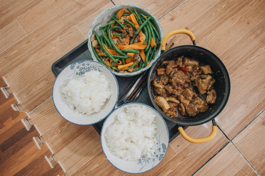 Two bowls of white rice and one bowl with cooked meat an done bowl with cooked vegetgables on the light brown table background. Top view. 8 Fastest Ways to Cook Rice on the Stove
