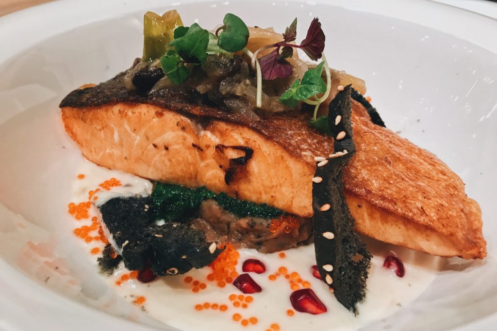 A cooked salmon fillet on a white plate