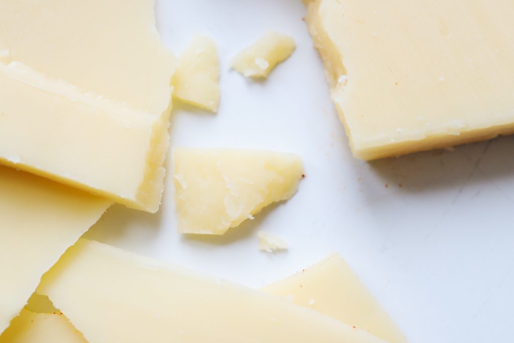 Several pieces of cheese of different sizes on white background